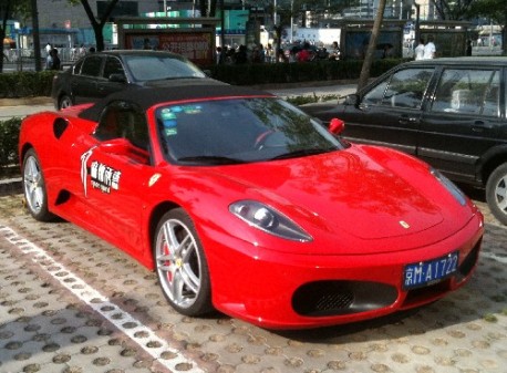 A very red Ferrari F430 Spider seen at a parking lot from a restaurant in my