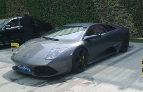 A grey Lamborghini Murcielago LP640 parked in front of a hotel somewhere in